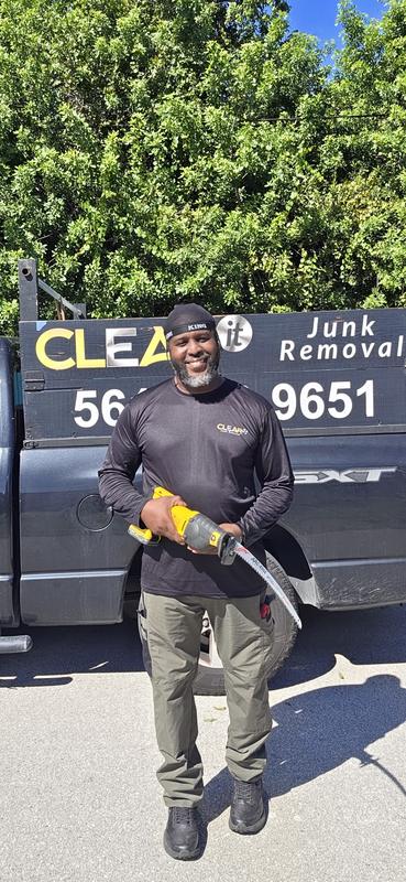 Sedric Simon with a saw beside the Clear It Junk Removal truck