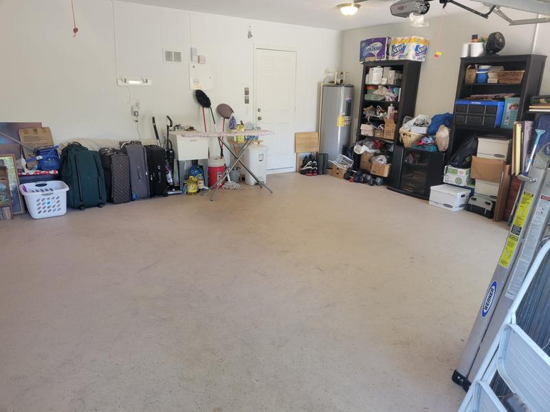 Garage mostly cleared out with remaining items along the walls
