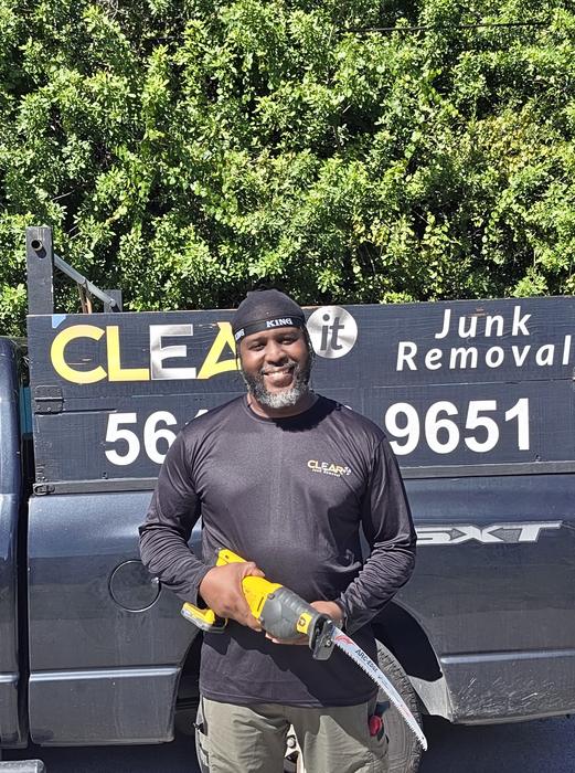 Sedric Simon, owner of Clear It Junk Removal, standing in front of his branded truck